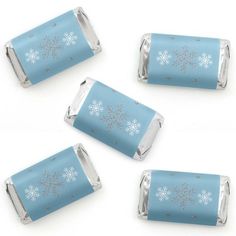 four pieces of blue candy with snowflakes on the top and one piece is silver