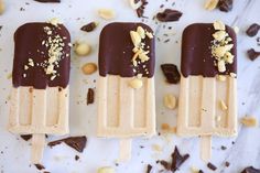 three ice creams with nuts and chocolate on top