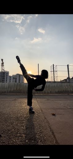 a person doing a hand stand in the middle of an empty street with buildings in the background