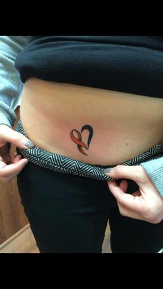 a woman is holding her stomach with an orange ribbon in the shape of a heart