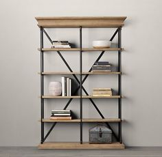 a bookshelf with several shelves and various items on it in front of a wall