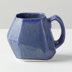 a blue vase sitting on top of a white table