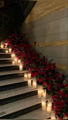 candles are lined up on the stairs with flowers