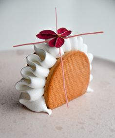 a piece of cake with white icing and red flowers on it sitting on a plate