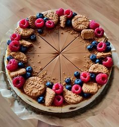 a cake with chocolate frosting, raspberries and blueberries on the top