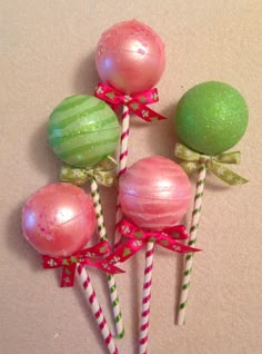 four candy lollipops with bows on them