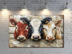 three cows standing next to each other in front of a brick wall with lights on