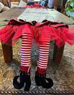 legs with red and white striped stockings on top of a wooden table in a living room