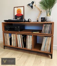 an old record player sits on top of a wooden shelf with records and other music equipment