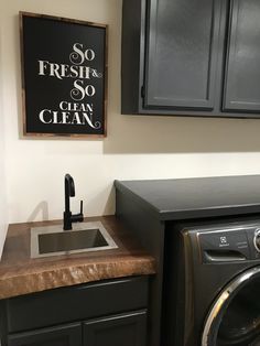 a washer and dryer sitting next to each other in a room with black cabinets