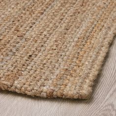 a close up view of the top of a rug on a wooden floor with wood floors