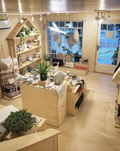 a room filled with lots of wooden furniture and shelves covered in plants, pots and other items