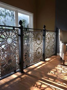 the sun shines through two windows onto a balcony with decorative ironwork on it