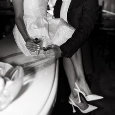 a man and woman standing next to each other in front of a counter with wine glasses