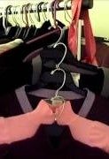 a person's arm hanging from a hanger in front of clothes on racks