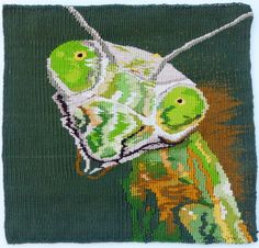 a close up of a painting of a green insect on a piece of cloth with white thread