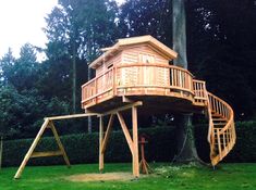 a tree house built into the side of a green field