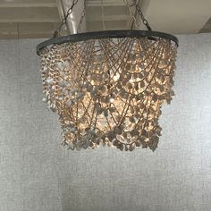 a chandelier hanging from the ceiling in a room with white walls and flooring