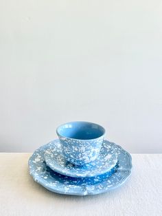 a blue cup and saucer sitting on top of a white table