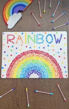 a rainbow craft with crayons and pencils next to it