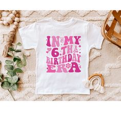 Celebrate her big day in style with our In My Birthday Era shirt! This trendy 6th birthday shirt is the perfect addition to any birthday girl's wardrobe. Whether she's celebrating her 6th birthday party or any special occasion, this personalized birthday shirt is sure to make her feel extra special. Handcrafted with love and attention to detail, this shirt is a must-have for the birthday girl in your life! We use premium t-shirts, hoodies which have a soft and light feel, It's very comfy and wit Six Year Old Birthday Shirt, Playful Pink T-shirt For Birthday, 6th Birthday Girl Shirt Svg, Pink Graphic Print T-shirt For First Birthday, It’s My Birthday Sequin Shirt, Kids Birthday Shirts, Personalized Birthday Shirts, Girls Wardrobe, Kids Graphic Tees