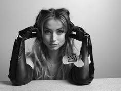 a woman sitting at a table with her hands on her head and wearing boxing gloves