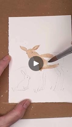 someone is drawing a deer on white paper