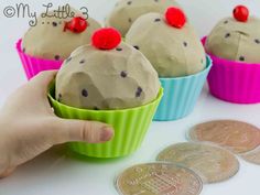 three cupcakes with chocolate frosting and sprinkles on them are being held by a person's hand