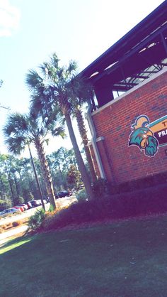 a brick building with palm trees in front of it and a sign that says pinehurst high school