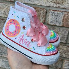 How adorable!  Rows of pastel pearls on the toes and donuts on the sides along with your little one's name in pink glitter script writing.  Please choose your child's size during check out. Feel free to contact me with any questions regarding sizing or anything else prior to your purchase.  I answer very quickly! Pink Round Toe Sneakers For Birthday, Cute High-top Sneakers For Birthday, Casual Pink Sneakers For Birthday, Donut Shoes, Personalized Converse, Shoes Sneakers High Tops, Bedazzled Shoes, Minnie Mouse Shoes, Painted Shoes Diy