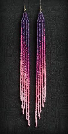 pink and purple beaded earrings on black background