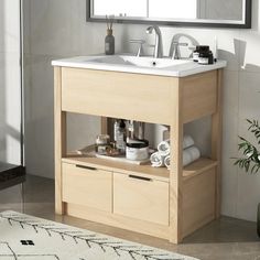 a bathroom with a sink, mirror and towel rack in it's corner next to a rug