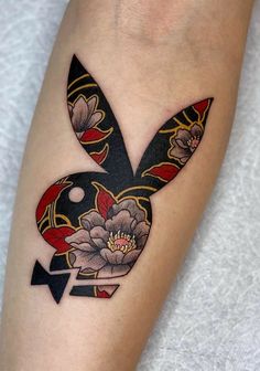 a tattoo on the leg of a woman with flowers and an arrow in it's center