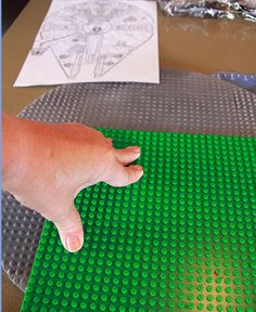 a hand is touching the top of a lego table