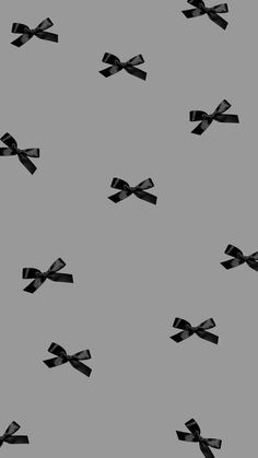 black bows are flying in the air on a gray background