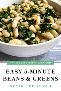 a white bowl filled with beans and spinach on top of a blue table cloth