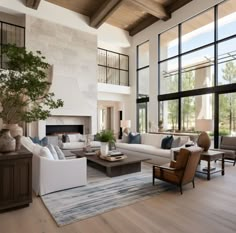 a living room filled with lots of furniture next to tall windows on the side of a wall