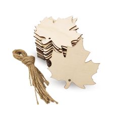 wooden cutouts of maple leaves and tassels with twine on white background