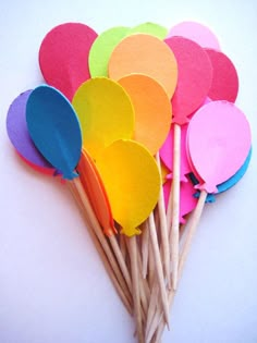 a bunch of colorful wooden paddles sitting next to each other on a white surface