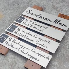 four wooden signs with names on them sitting on the ground