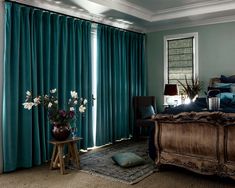 a bed room with a neatly made bed and green drapes on the windowsill