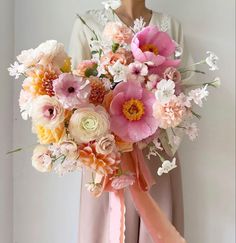 a woman holding a bouquet of flowers in her hands