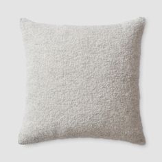 a white pillow that is made out of wool and has a light gray color scheme