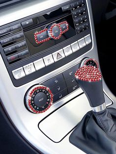 an automatic gear stick with red and black beads on it's center console in a car