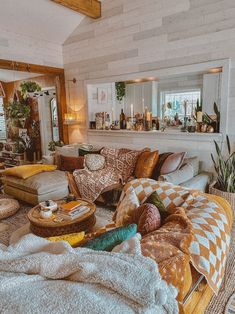 a living room filled with lots of furniture and pillows on top of a wooden floor