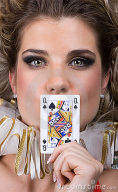 a woman holding up a playing card in front of her face