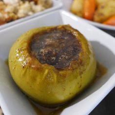 a close up of a plate of food with some vegetables in the bowl behind it