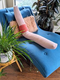 a blue chair with pillows and plants on it