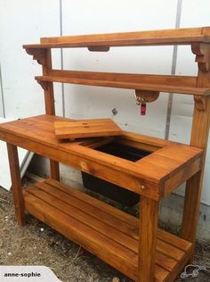 a wooden potting bench sitting next to a white wall