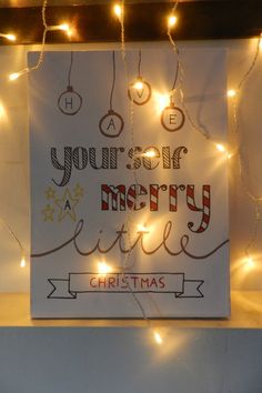 a christmas card hanging on a wall with lights